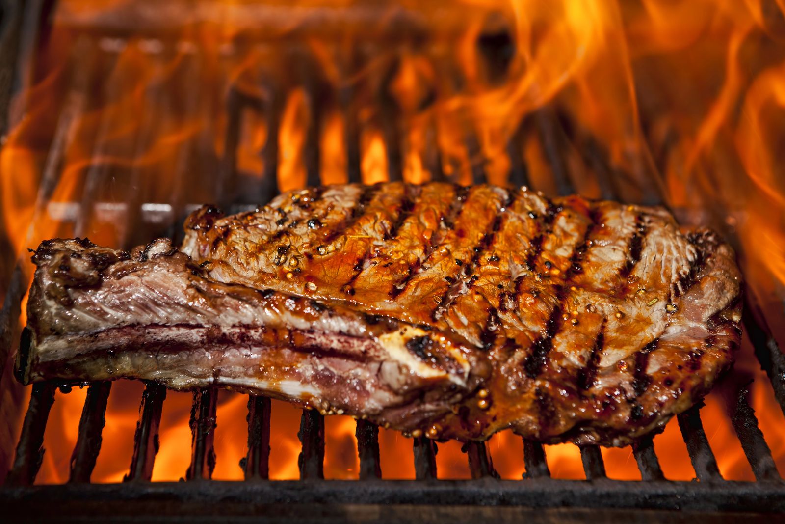 Saftiges Steak auf dem Holzkohlegrill mit offenem Feuer